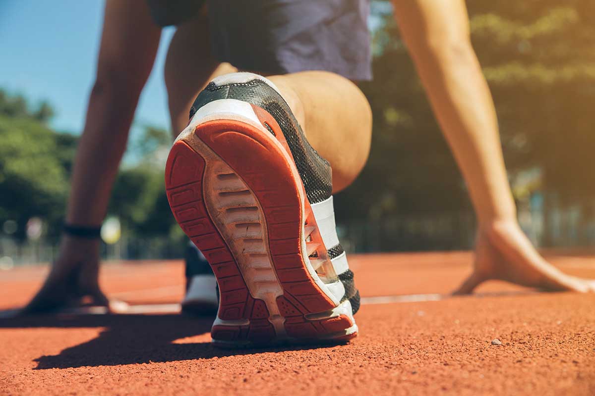 athlete wearing sports shoes at race track runner set up at the starting line sports gear related to graphene