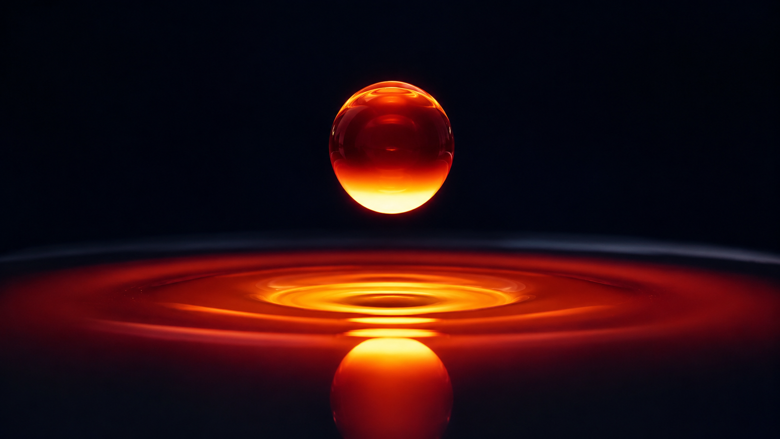 A crucible of molten salt glowing incandescent orange-white in a dark furnace chamber, its liquid surface perfectly flat and mirror-still, a single suspended probe just touching the meniscus and drawing a faint bright ripple — heat, liquid and instrument in one quiet moment